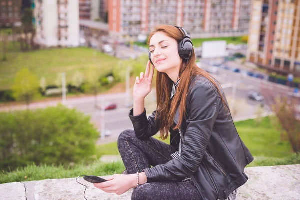 Poslech hudby dívka v parku ve městě — Stock fotografie