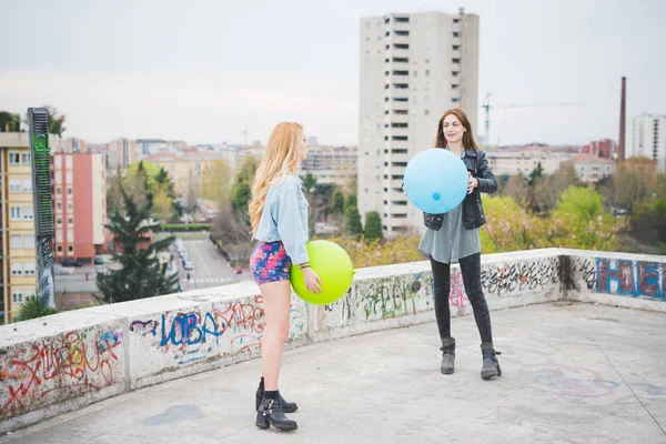 Meisjes spelen met ballonnen in stad — Stockfoto