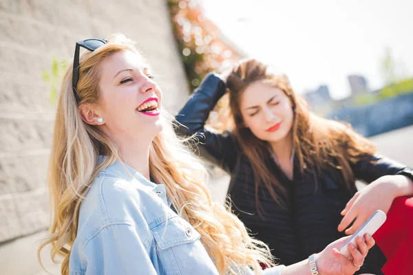 Donne sedute all'aperto utilizzando smartphone — Foto Stock