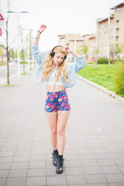 Blonde girl listening music dancing — Stock Photo, Image