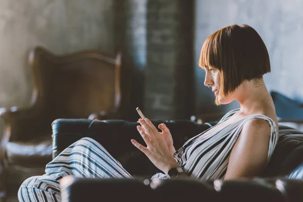 Young Beautiful Woman Indoor Sitting Couch Using Smart Phone Texting — 스톡 사진