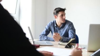 Genç beyaz iş adamı akıllı telefon kullanıyor. Çalışma masasında oturuyor. Teknoloji, iş dünyası, sosyal ağ konsepti.