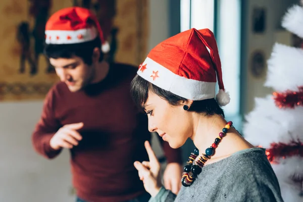 Erkek ve kadın Noel ağacı süslüyorlar.