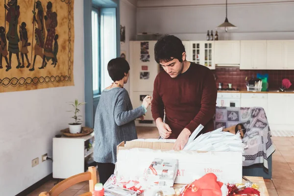 Erkek ve kadın Noel ağacı süslüyorlar. — Stok fotoğraf