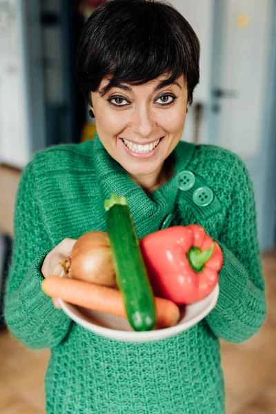 Kvinna anläggning skål med grönsaker — Stockfoto