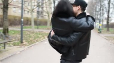 Genç bir adam dışarıda genç bir kadını taşırken daireler çizerek eğleniyor. Mutluluk, her şeyden uzaklaşmak, olumlu duygu kavramı.