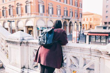 Arkaya bakan genç kadın eğik korkuluklara bakıyor - özgür, gezgin, kıvrımlı konsept