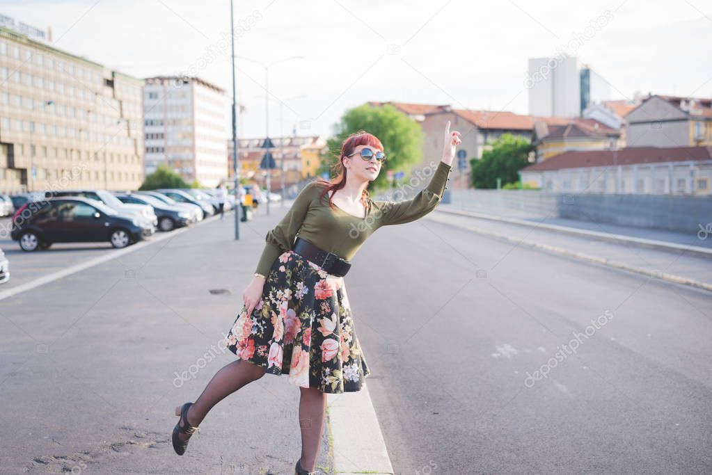 young woman in city hitchhiking
