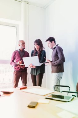 Tablet ve Not Defteri gibi teknolojik cihazlar ile birlikte çalışan çok ırklı iş adamları bağlı 