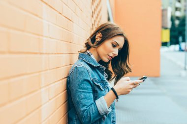 açık havada akıllı telefon - sosyal ağ, Internet, online kavramı kullanan genç kadın