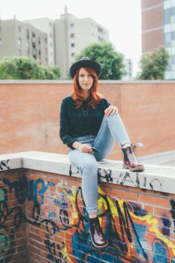 küçük duvar akıllı telefon - teknoloji, müşteri kavramı holding kamera seyir oturan genç kadın Kızıl saçlı 