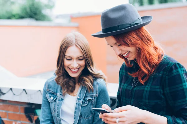 两名年轻女子户外使用智能手机有乐趣 社会网络 通信概念 — 图库照片