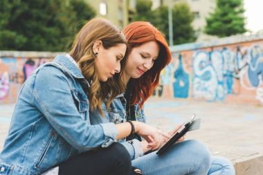 iki genç kadın eğleniyor - akıllı telefon kullanarak açık teknoloji, sosyal ağ, iletişim kavramı 