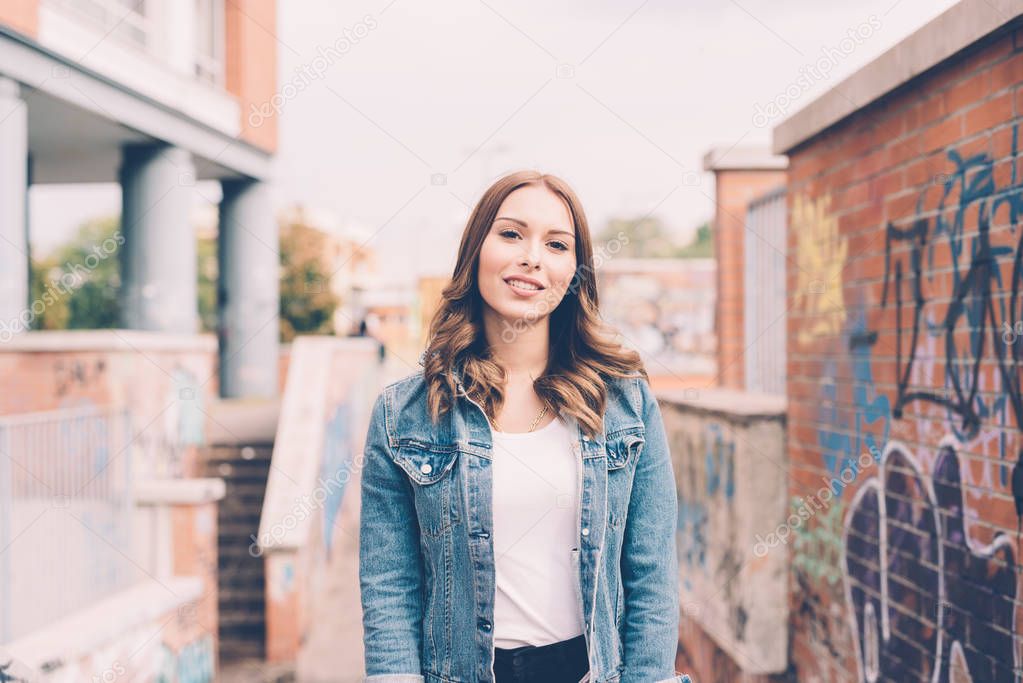 portrait of young woman outdoor looking camera smiling - happiness, serene, customer concept 