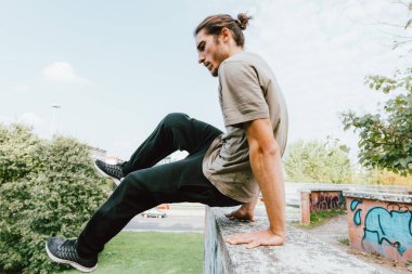 Sonbaharda kentin açık Parkour yapan genç güzel beyaz erkek 