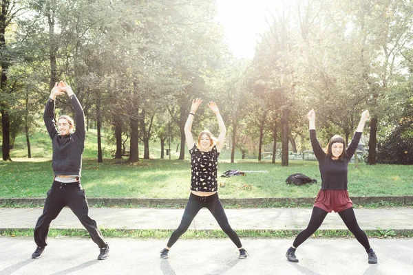 Genç kadın ve erkekler açık havada havaya kaldırarak zıplattılar yapıyor ışık geri 