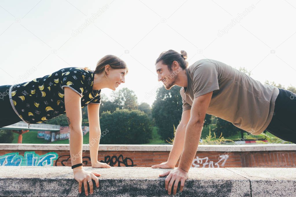 young man and woman athlete stretching outdoor 
