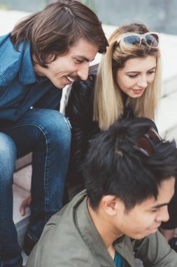 Grup arkadaşları çok ırklı oturan smartphone kullanarak açık 