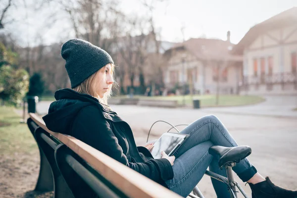 タブレットを使用してベンチに座って市屋外若い美しい女性 — ストック写真