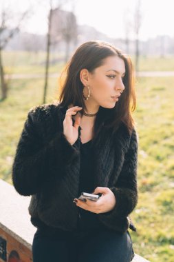 Genç güzel kadın uzak smartphone kullanarak seyir açık