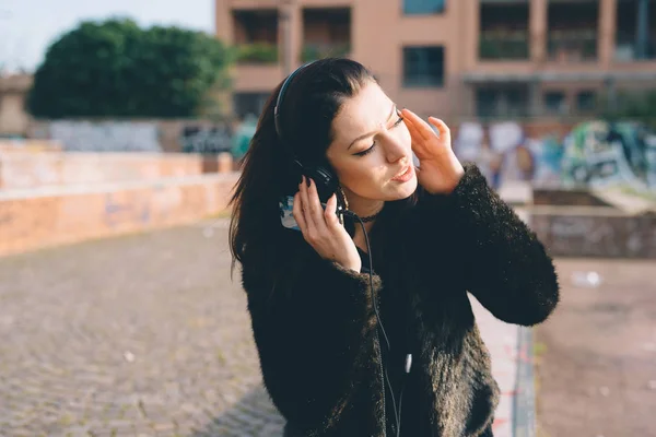 スマート フォンで音楽を聴く若い美しい女性屋外 — ストック写真