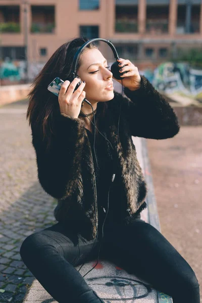 年轻美丽的女人户外听音乐与智能手机 — 图库照片