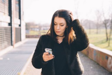 Genç güzel kadın smartphone kullanarak açık 