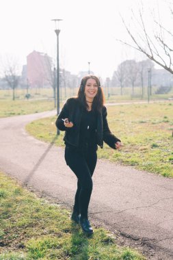 Genç güzel kadın smartphone kullanarak açık müzik dinleme