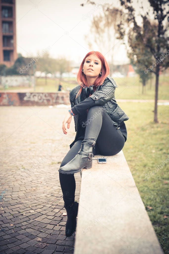 young redhead woman venezuelan sitting outdoor in the city looking camera