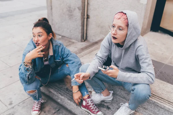 スマートフォンを使用して屋外で2人の若い女性 オンライン 若者文化 ソーシャルネットワークの概念 — ストック写真