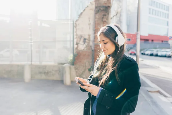 Mladá Žena Pózuje Městě Poslech Hudby Sluchátka Pomocí Chytrého Telefonu — Stock fotografie