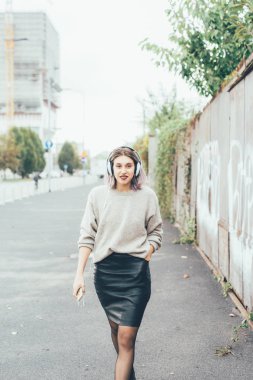 Baş telefon ve smartphone ile müzik dinleme yürüme şehirde açık genç güzel beyaz mor gri saçlı kadın 