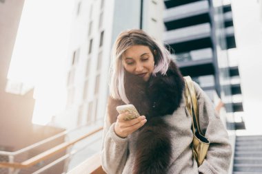 Şehirde gülümseyerek telefonu kullanan genç güzel beyaz mor gri saçlı kadın 