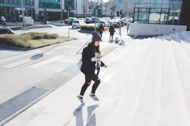 Açık yürüyen genç kadın smartphone kullanarak
