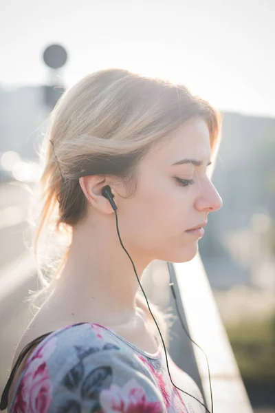 Stående Ung Kvinna Utomhus Tittar Sidledes Lyssnar Musik — Stockfoto