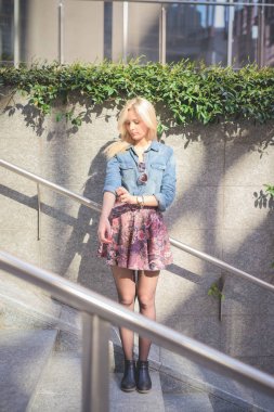 Genç güzel sarışın beyaz kız kot gömlek ve bakan çiçek etek giyiyor şehirde açık poz