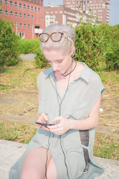 Молодая Женщина Сидит Открытом Воздухе Слушать Музыку Смартфоном — стоковое фото