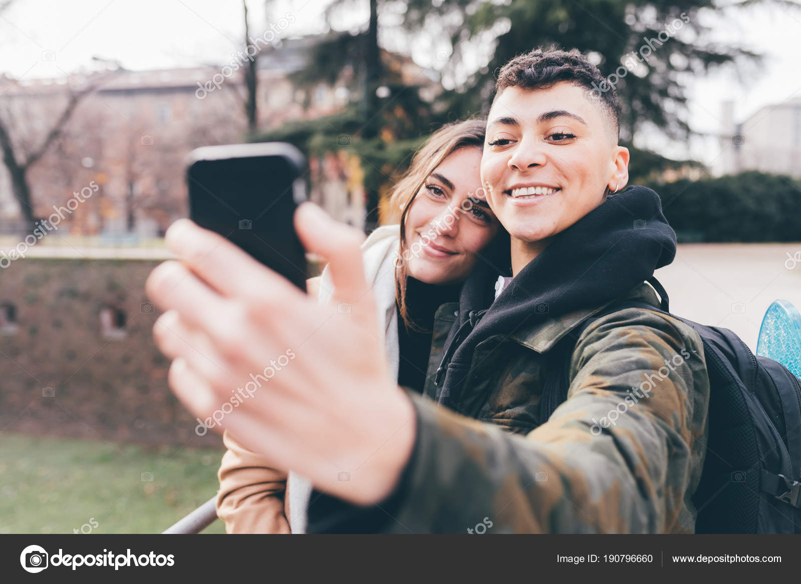 Two Women Lesbian Couple Outdoors Using Smart Phone Taking Selfie Stock Photo by 190796660