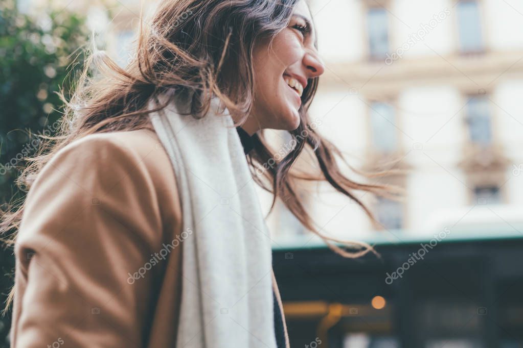 young woman walking outdoors smiling - happiness, positive emotions, getting away from it all concept