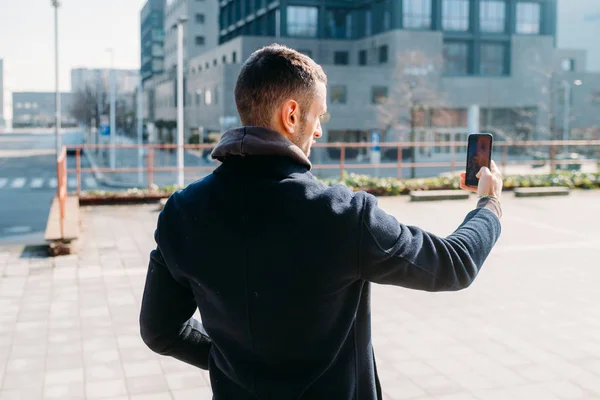 Młody Człowiek Odkryty Przy Użyciu Smartfona Uchwyt Ręczny Biorąc Selfie — Zdjęcie stockowe