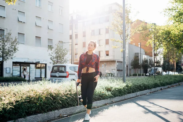 Mujer Joven Caminando Aire Libre Sosteniendo Monopatín —  Fotos de Stock