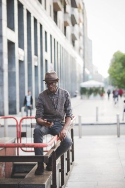 Genç yakışıklı Afrika adam şehirde Smartphone kullanarak