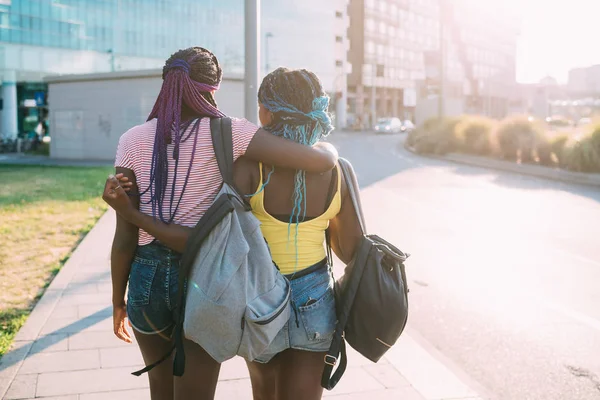 Due sorelle che camminano all'aperto abbracciandosi — Foto Stock