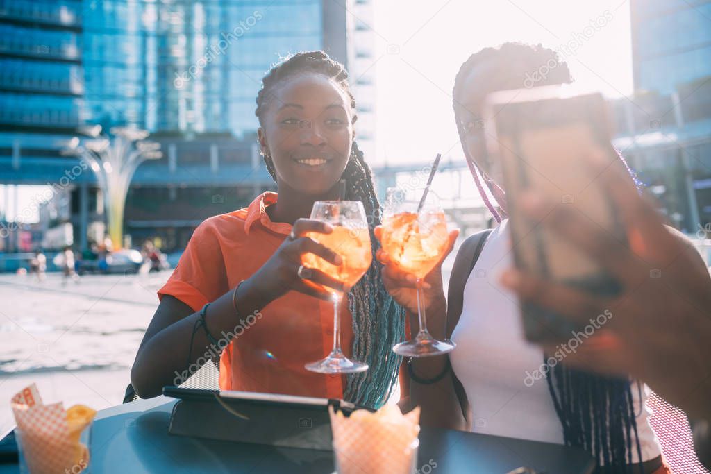 two women sisters sitting outdoor taking selfie