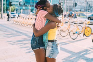 Orta bölüm iki kız kardeş dışarıda gülümsüyor.