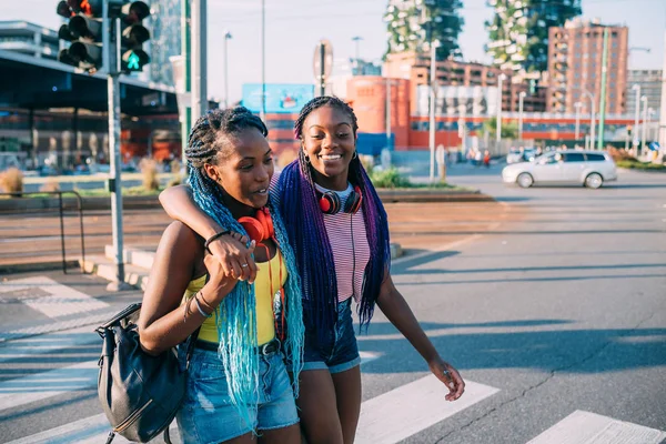 Due sorelle che camminano all'aperto abbracciandosi divertendosi — Foto Stock