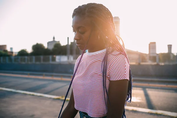 Νεαρή όμορφη μαύρη γυναίκα στέκεται μόνη της εξωτερική πίσω φως στυλό — Φωτογραφία Αρχείου