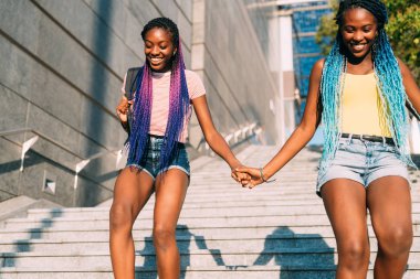 İki güzel siyah kız kardeş birlikte aşağı iniyor.