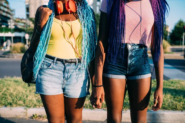 Sección media dos jóvenes mujeres negras al aire libre cogidas de la mano —  Fotos de Stock