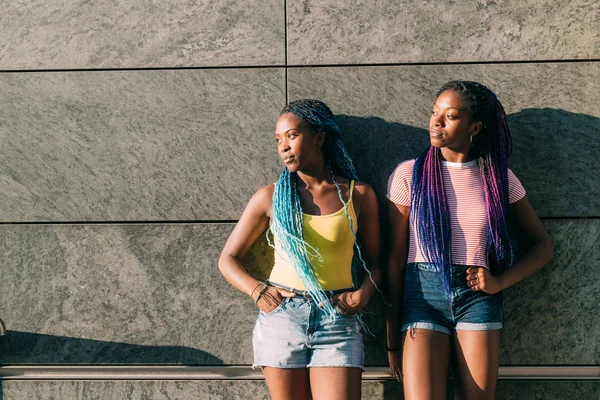 Two young beautiful black sisters outdoor posing looking over — 스톡 사진